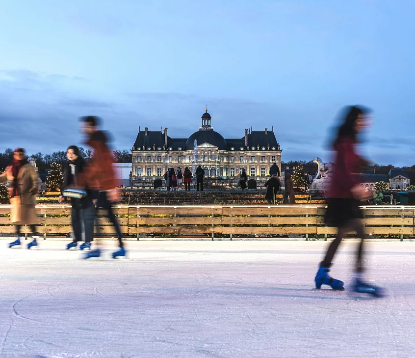 Familles profitant de la patinoire éphémère du jardin de Vaux-le-Vicomte à Noël